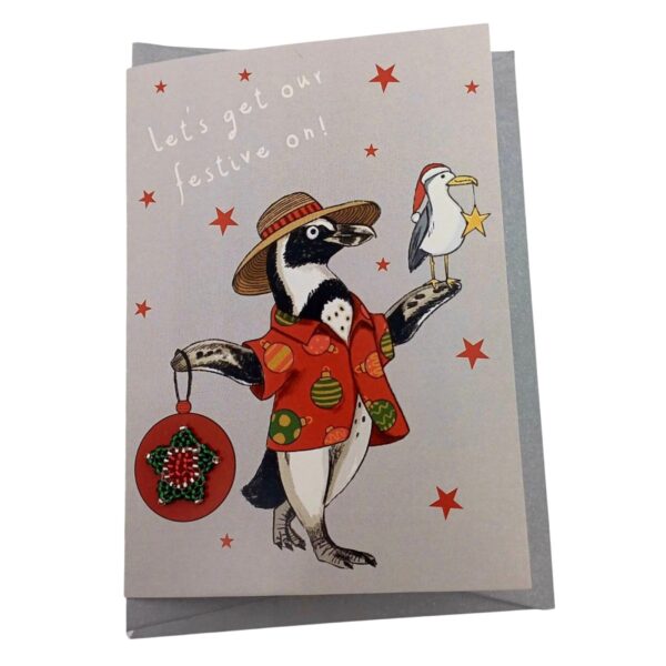A cute christmas card featuring a penguin wearing a sunhat