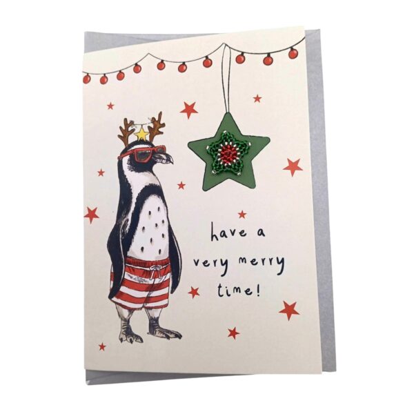 A cute Christmas card with a penguin wearing antlers and sunglasses.